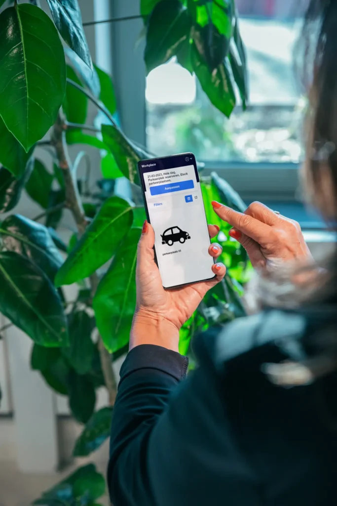 Een persoon gebruikt een mobiele app om een parkeerplaats te reserveren.