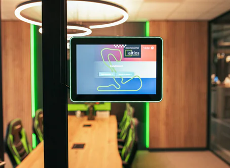 Zaaldisplay bij vergaderruimte met groene ring en tafel in moderne kantooromgeving.